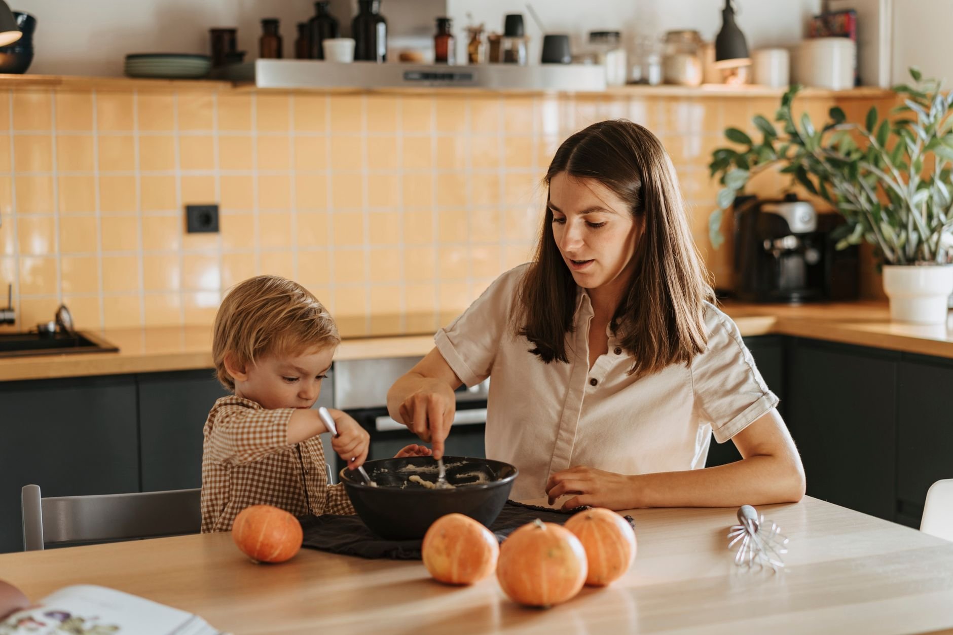 A mother and child bond over baking in a warm kitchen setting