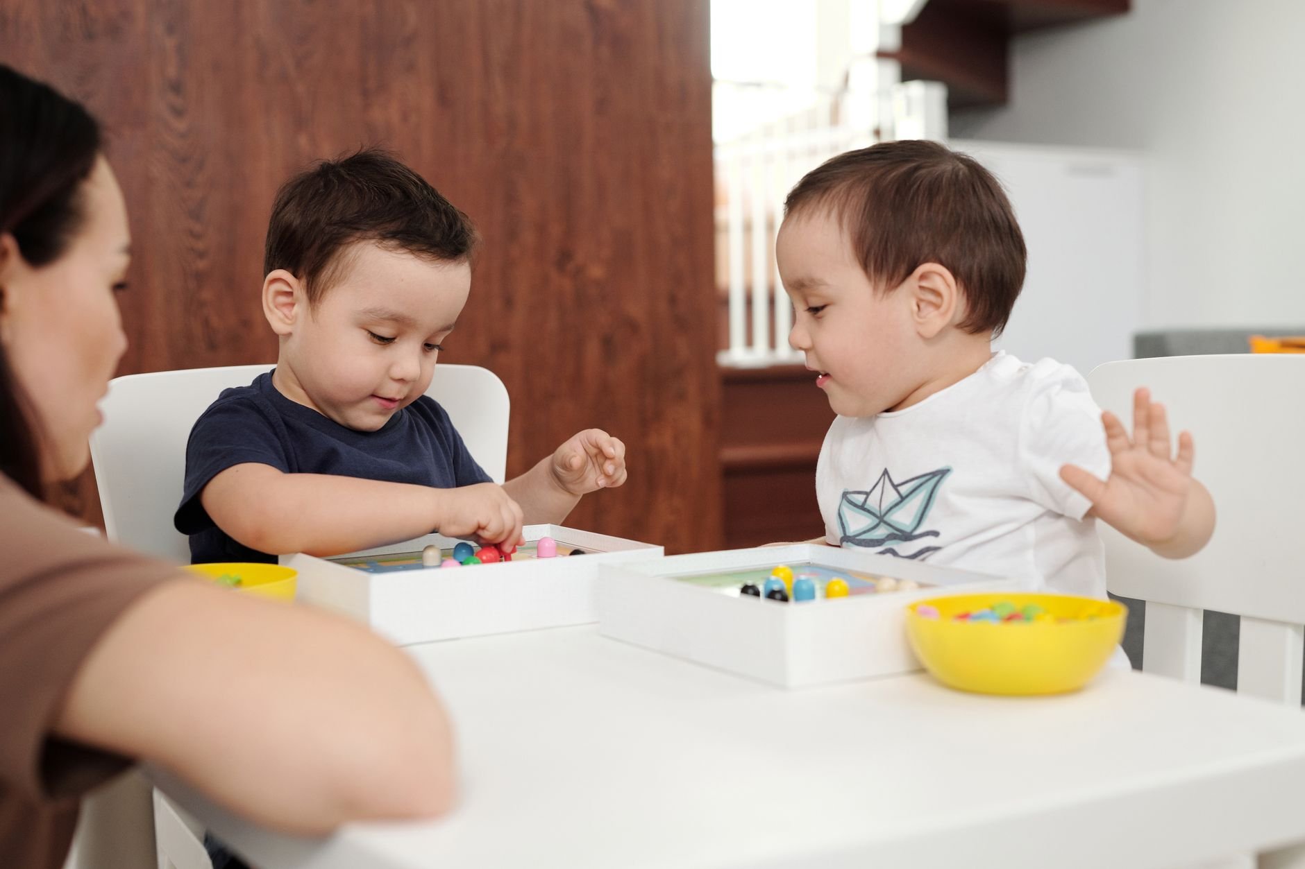 Child playing with toys under the supervision of a caring adult