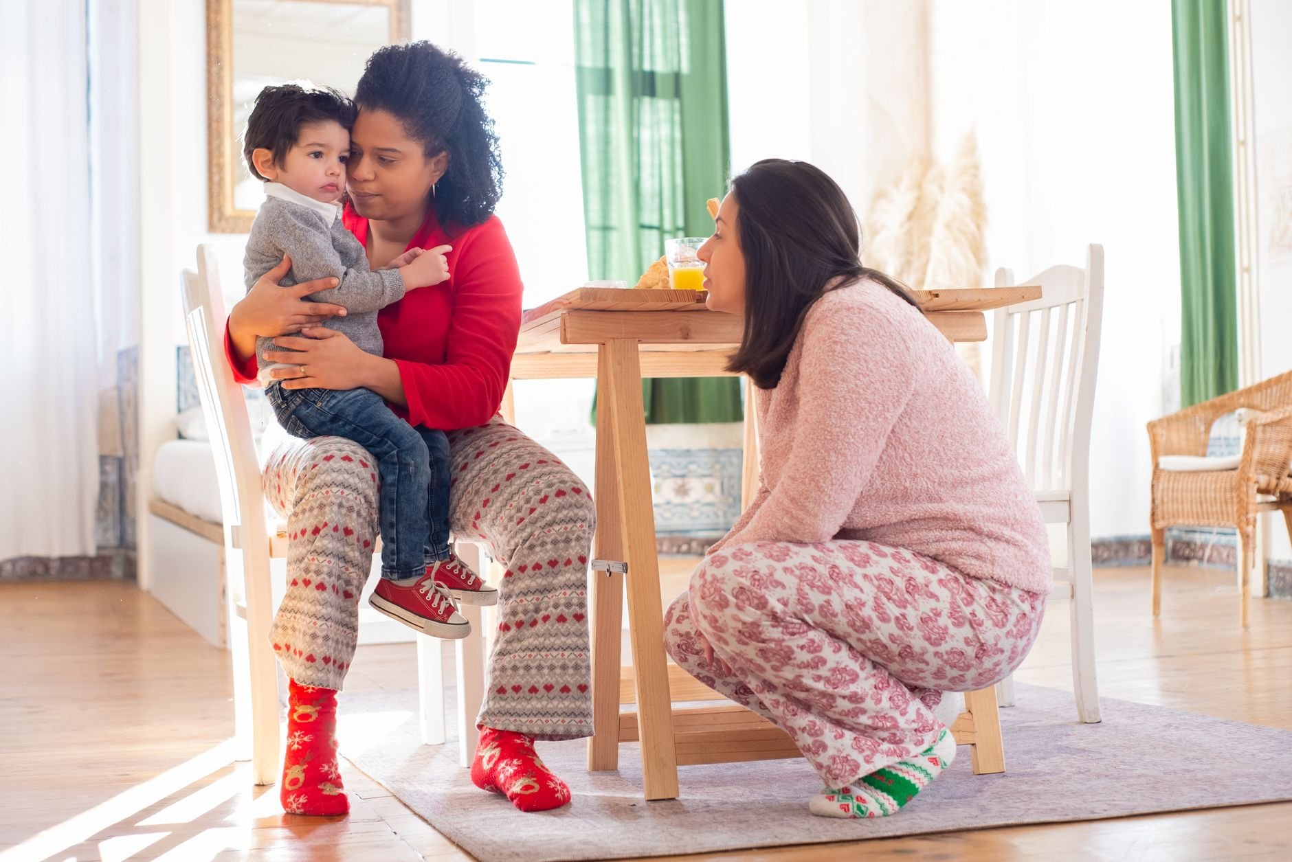 Mothers sitting together with their child in a cozy living room